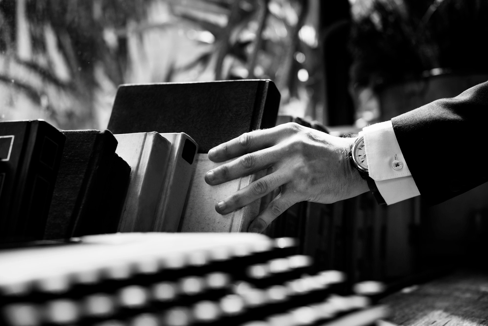 Image d'une main attrapant un livre dans une bibliothèque, symbolisant ici une spécialité de BTN avocats : le droit des affaires